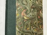 un gros plan d'un livre posé sur une surface blanche, avec une couverture verte