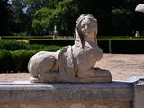 a statue of a woman sitting on a stone bench