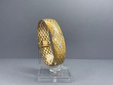 a close up of a bracelet on a stand on a gray surface