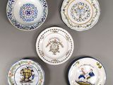 quatre assiettes ornées de motifs différents, posées sur un fond gris