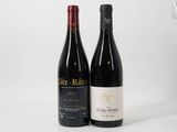 two bottles of wine sitting next to each other on a white surface