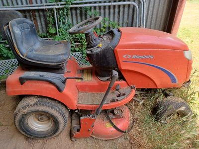 a lawn mower that is sitting in the grass