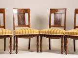 trois chaises en bois dont les assises sont recouvertes d'un tissu rayé jaune et blanc