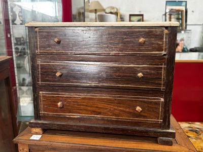 une petite commode en bois posée sur une table