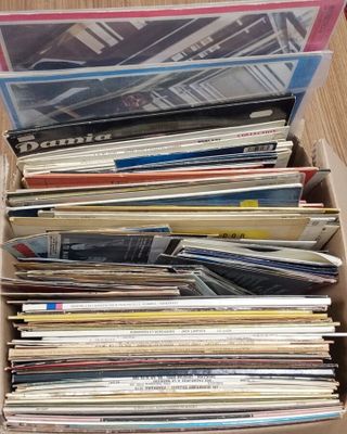 une boîte remplie de disques vinyles posée sur une table