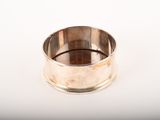 une bague en argent posée sur une surface blanche