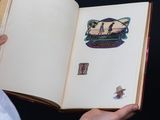 a person holding an open book with stickers on it