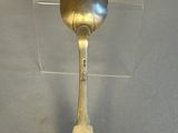 a silver spoon with a gold spoon handle on a table