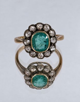 a close up of a gold ring with two emerald stones