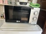 a microwave sitting on top of a refrigerator in a kitchen