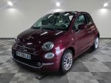 the small red car is parked on a checkered tile floor