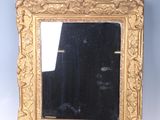 a gold framed mirror with a black background