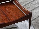 a small wooden bench sitting on a sidewalk next to a sidewalk