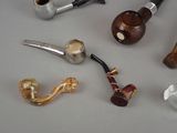 a lot of different types of smoking pipes on the table