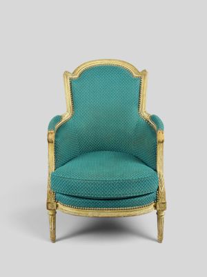 a blue chair with gold trim and a green upholstered seat