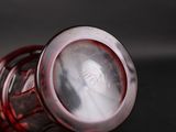 a person holding a glass with a liquid inside of it