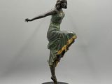 statue en bronze représentant une femme vêtue d'une robe verte, posée sur un socle noir