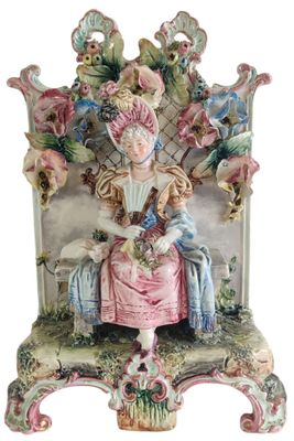 a figurine of a woman sitting on a bench