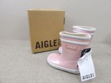 a pair of pink rain boots sitting next to a box