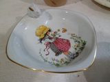 une assiette sur laquelle est représentée une fille et un oiseau