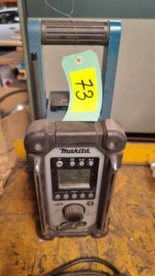 une radio posée sur une table, sur laquelle est collé un autocollant jaune