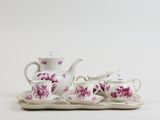 an image of a tea set on a tray on a white surface
