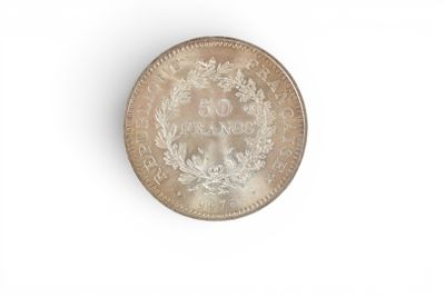 an old silver coin on a white surface with a white background