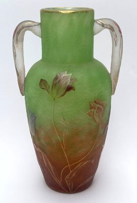 a green vase with a floral design on it