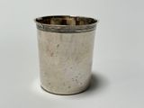 a silver cup that is sitting on a white surface