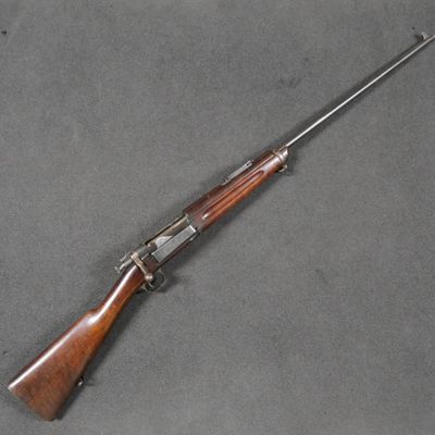 an old rifle with a wooden handle on a gray surface