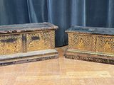 two wooden chests sitting next to each other on a wooden floor
