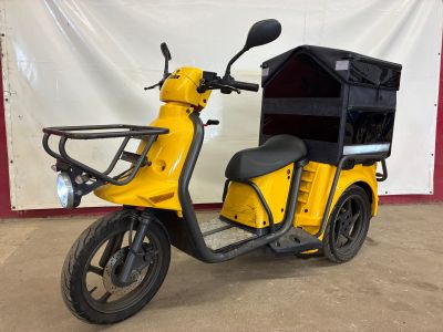 une photo d'un scooter jaune garé dans un garage
