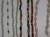 many necklaces that are hanging on a wall