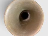 a brown vase with a black hole in it