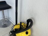a yellow vacuum cleaner sitting on top of a tiled floor next to a bar stool