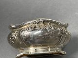 a close up of a silver plate with a flower design on it