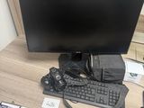 a computer monitor and keyboard on a desk next to a cell phone