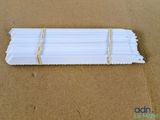 un gros plan sur un tas de bâtonnets en papier blanc posés sur une surface marron