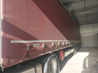 a red semi truck parked inside of a building