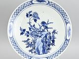 assiette bleue et blanche ornée d'un oiseau et de fleurs