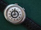 a close up of a watch on a green surface