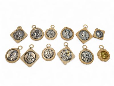 a bunch of gold and silver religious charms on a white background