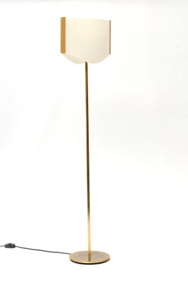 un lampadaire doré surmonté d'un abat-jour blanc
