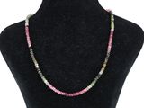 un collier composé de perles multicolores sur un mannequin noir