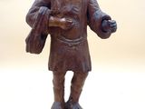 une statue représentant un homme tenant un sac