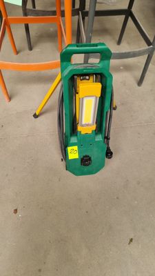 an image of a green machine sitting on top of a cement floor