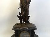 une statue représentant une femme tenant un enfant dans ses bras, au sommet d'une horloge