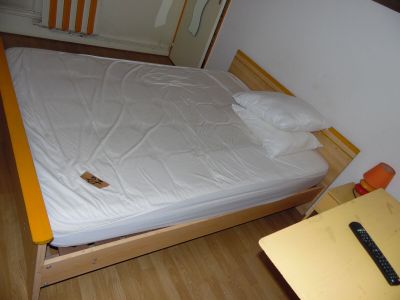 a bed with a white sheet on it in a small room
