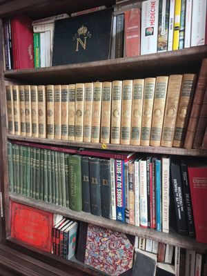 a book shelf with many books on it in a room