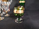 a green glass with a candle inside of it on a table